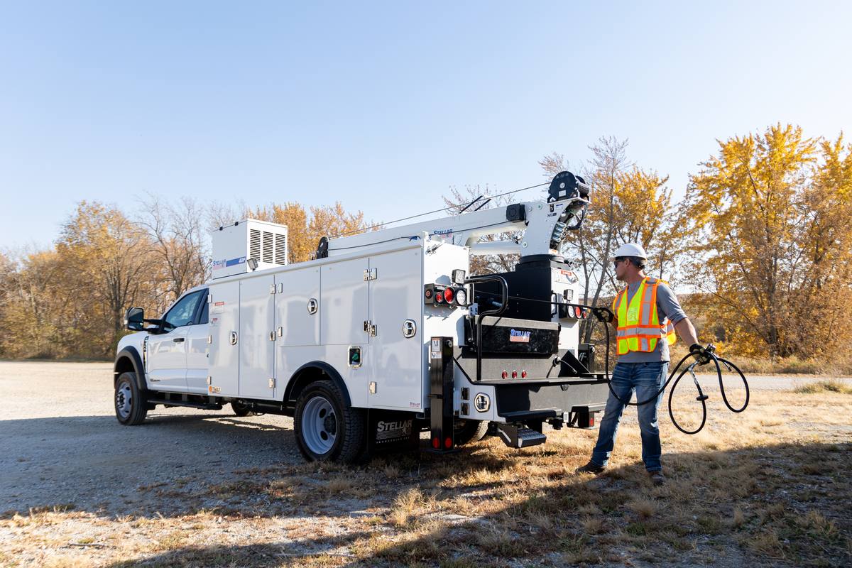 Technician pulling a hose from the rear of a Stellar TMAX 1 mechanic truck