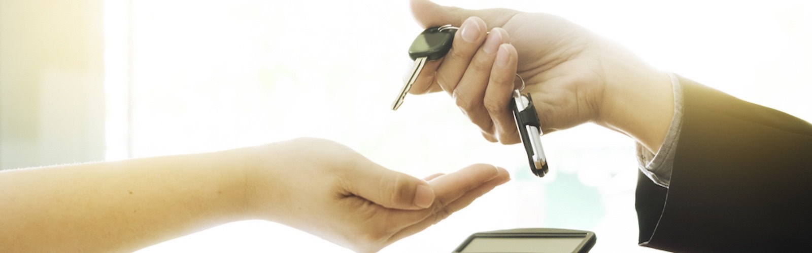 Car Salesperson handing over new car keys to customer